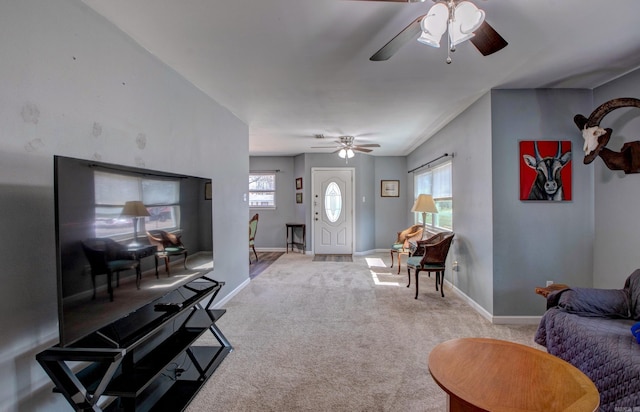 carpeted living room featuring ceiling fan and baseboards