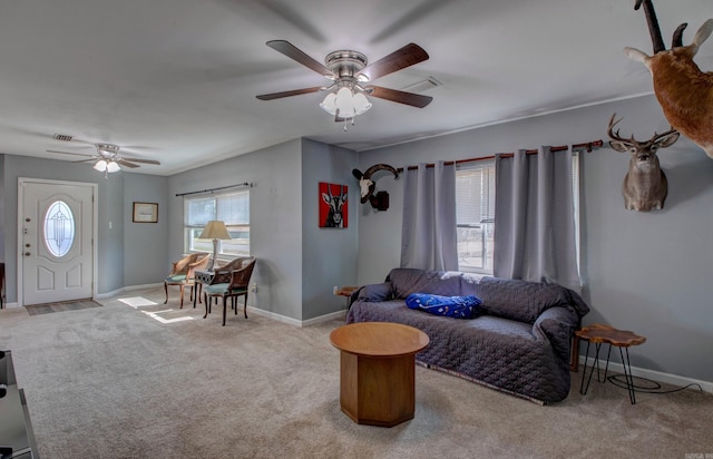 carpeted living area with visible vents, baseboards, and a ceiling fan