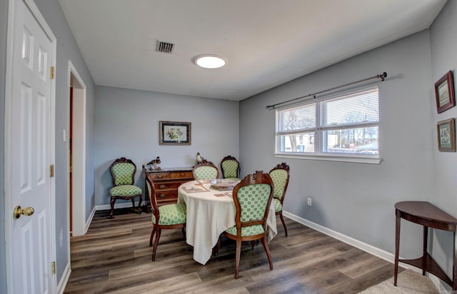 dining room with visible vents, baseboards, and wood finished floors