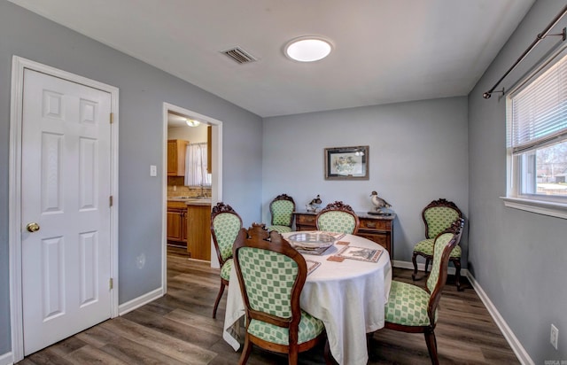 dining area with visible vents, baseboards, and dark wood finished floors