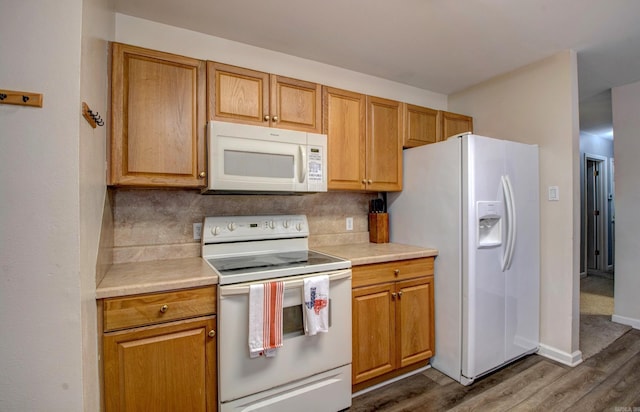 kitchen with white appliances, light countertops, and backsplash