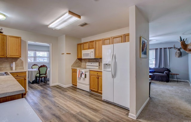 kitchen with decorative backsplash, white appliances, light countertops, and visible vents