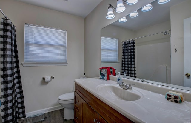 bathroom with vanity, a shower with shower curtain, wood finished floors, baseboards, and toilet