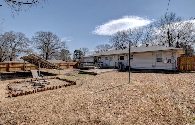 back of property with a deck and a fenced backyard