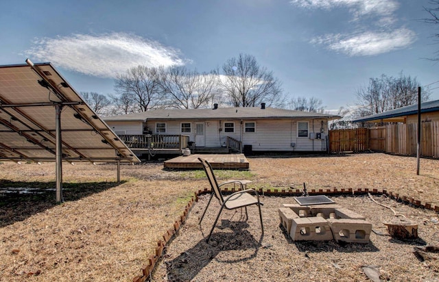 back of property with a garden, a wooden deck, and fence