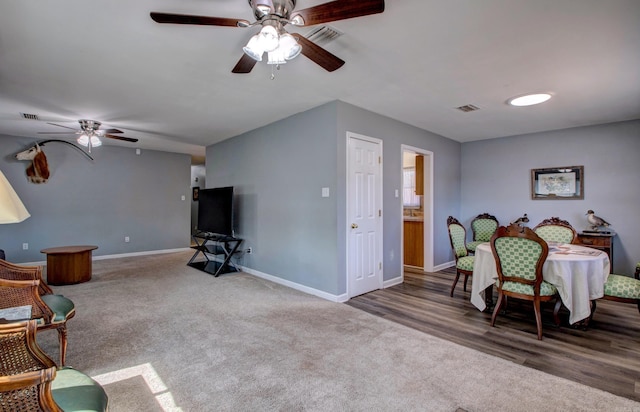 carpeted living area featuring visible vents, baseboards, and ceiling fan