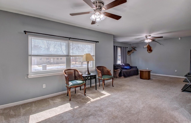 sitting room featuring ceiling fan, baseboards, and carpet