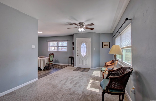 entryway with a ceiling fan, carpet, and baseboards