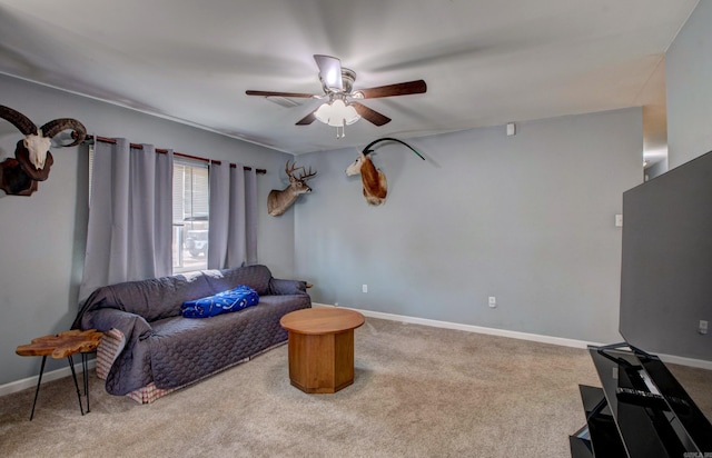 living room featuring carpet flooring, baseboards, and ceiling fan