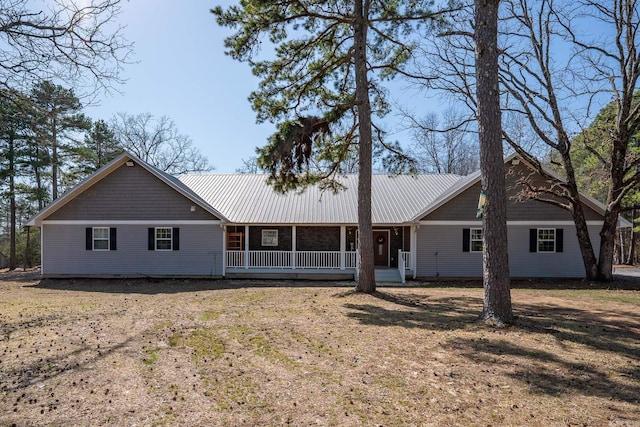 rear view of property featuring covered porch and metal roof