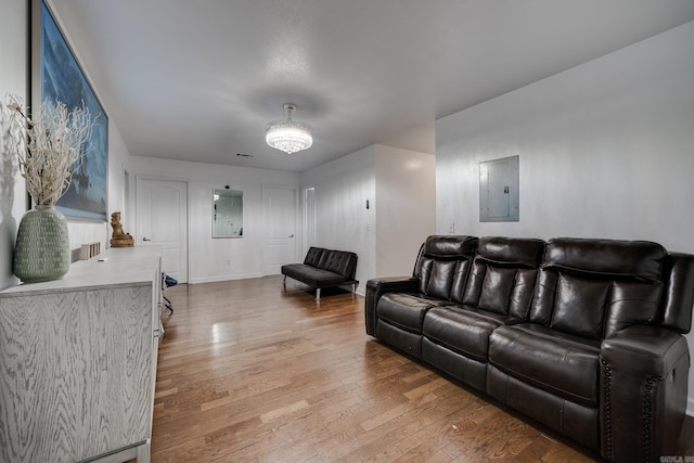 living area featuring electric panel, baseboards, and wood finished floors