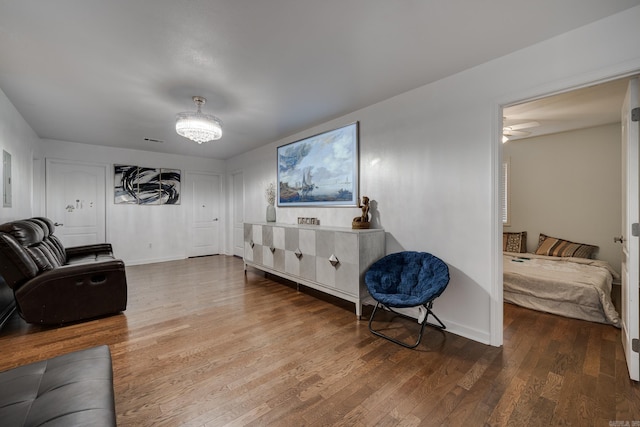 living area featuring visible vents, baseboards, wood finished floors, and a ceiling fan