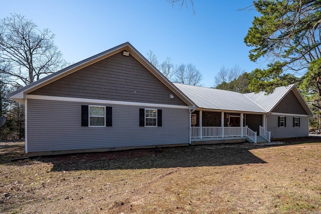 back of property with crawl space, covered porch, and metal roof