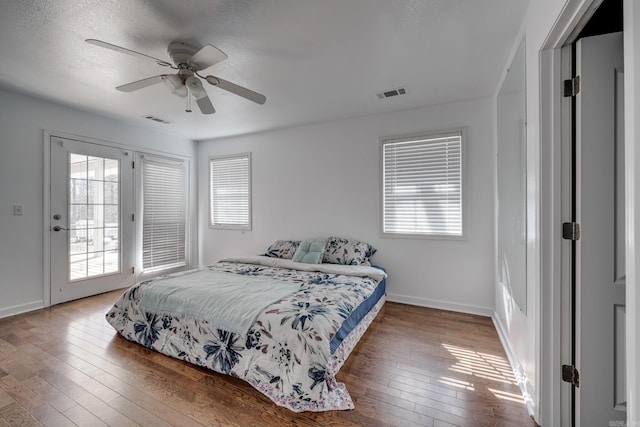 bedroom with access to outside, baseboards, visible vents, and wood-type flooring