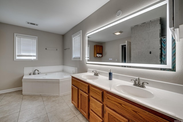 bathroom featuring tile patterned floors, visible vents, a bath, and a sink