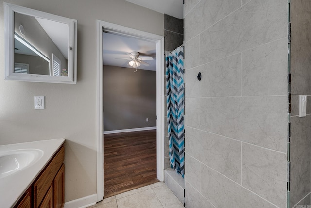 bathroom featuring tile patterned floors, a shower with curtain, a ceiling fan, baseboards, and vanity