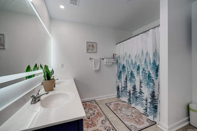 bathroom featuring tile patterned floors, double vanity, visible vents, and a sink