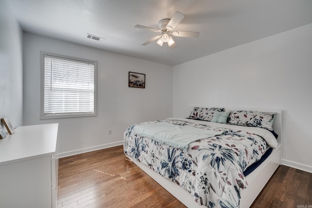 bedroom with visible vents, ceiling fan, baseboards, and hardwood / wood-style floors