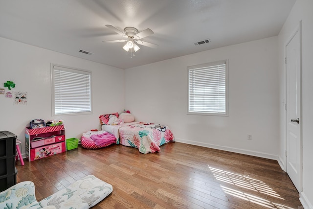 bedroom featuring visible vents, wood-type flooring, baseboards, and a ceiling fan