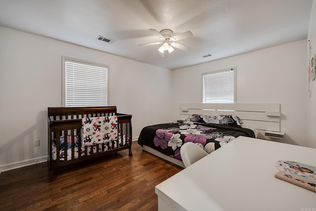 bedroom with ceiling fan, visible vents, baseboards, and wood finished floors