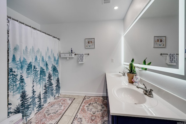 full bathroom featuring tile patterned floors, visible vents, a sink, double vanity, and baseboards