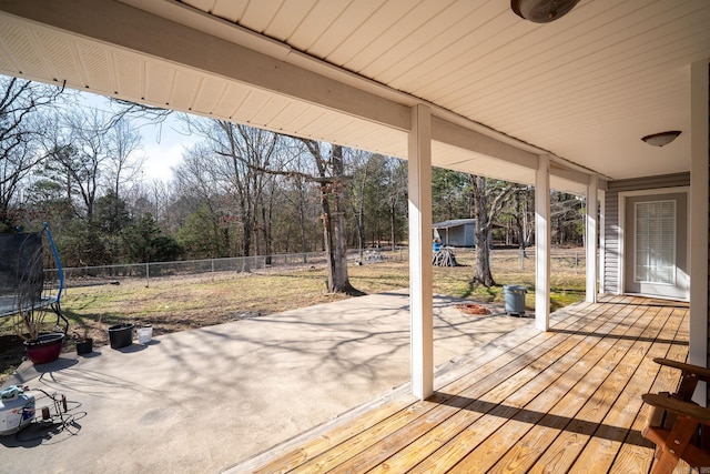 deck with a trampoline, fence private yard, and a patio area