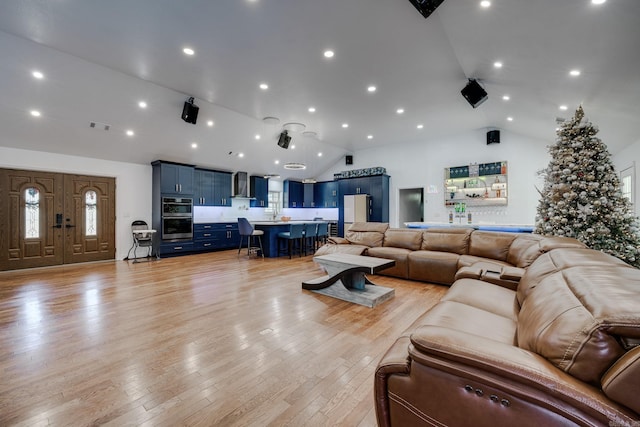 living area featuring recessed lighting, visible vents, light wood-type flooring, and high vaulted ceiling