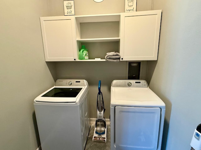 laundry area with washing machine and clothes dryer and cabinet space