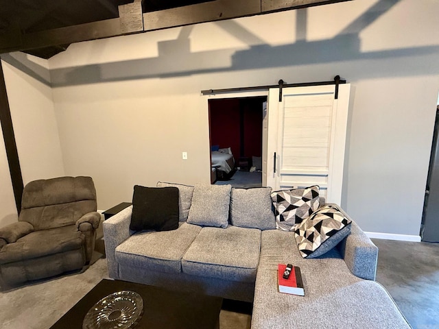 living room featuring a barn door, baseboards, and concrete floors