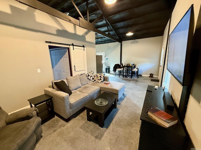 living room with a barn door, baseboards, and concrete flooring