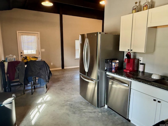 kitchen with white cabinets, baseboards, concrete flooring, and stainless steel appliances