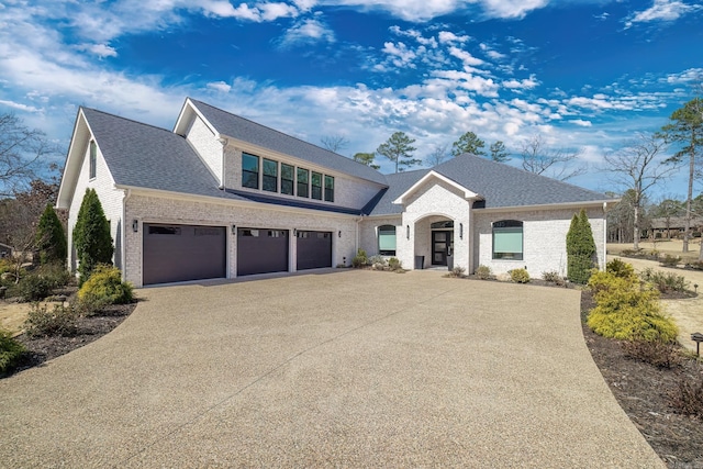 view of front of house featuring an attached garage, brick siding, driveway, and roof with shingles