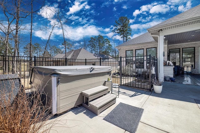 view of patio featuring fence and a hot tub