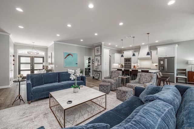 living room with recessed lighting, french doors, light wood-type flooring, and ornamental molding