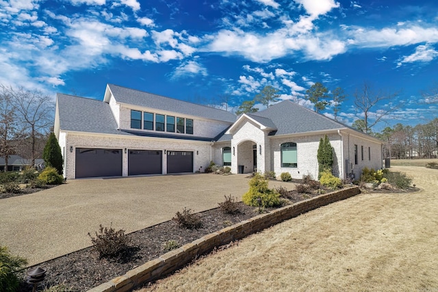 view of front of property featuring a front yard, driveway, an attached garage, a shingled roof, and brick siding