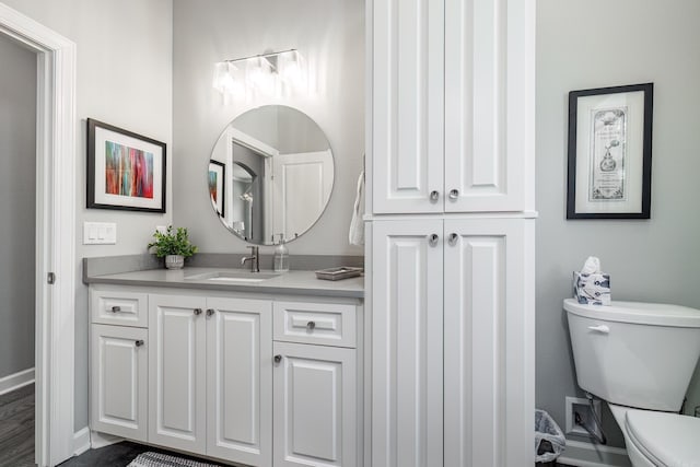 bathroom featuring vanity, toilet, and baseboards