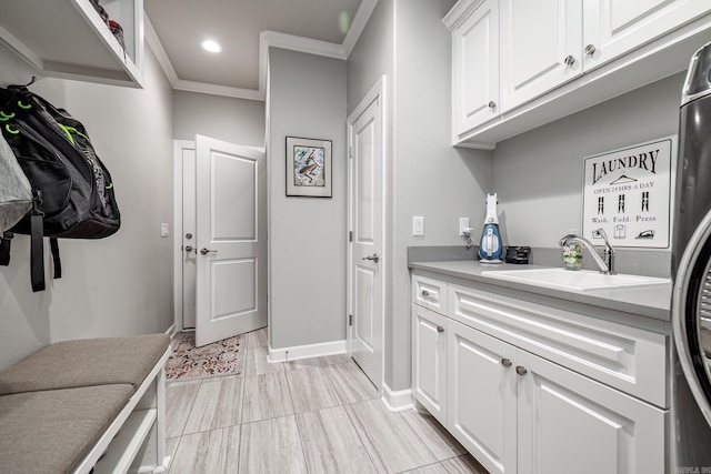 washroom featuring baseboards, ornamental molding, recessed lighting, cabinet space, and a sink