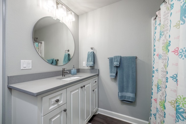 bathroom with vanity, wood finished floors, and baseboards