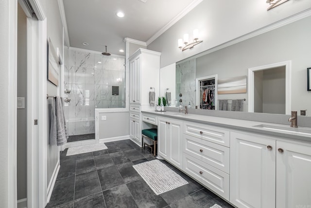 bathroom featuring a marble finish shower, ornamental molding, double vanity, and a sink