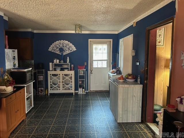 kitchen featuring a textured ceiling and crown molding