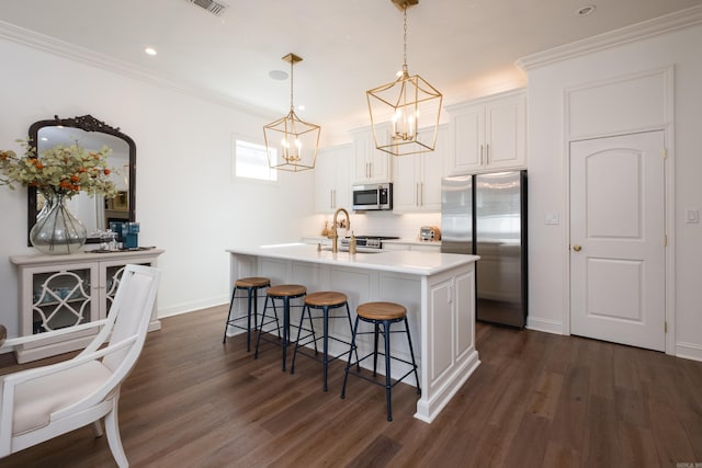 kitchen featuring dark wood-type flooring, a breakfast bar, a kitchen island with sink, a sink, and appliances with stainless steel finishes