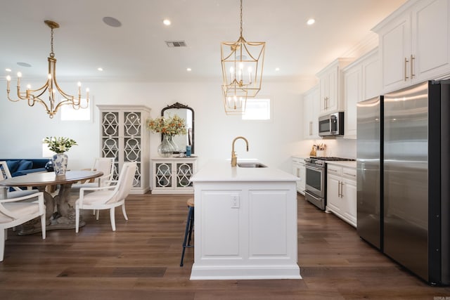 kitchen featuring visible vents, a sink, appliances with stainless steel finishes, crown molding, and a chandelier