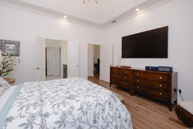 bedroom with visible vents, a high ceiling, light wood-style flooring, recessed lighting, and crown molding