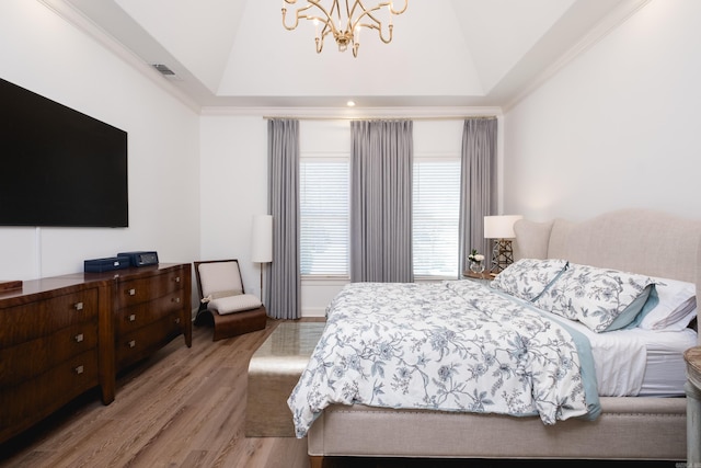 bedroom with a chandelier, multiple windows, visible vents, and wood finished floors