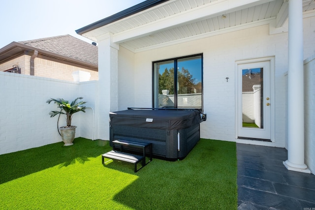 view of patio / terrace with a hot tub and fence