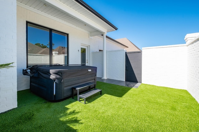 view of yard with fence and a hot tub