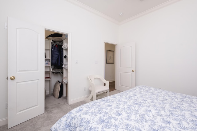 bedroom featuring a walk in closet, light carpet, a closet, crown molding, and baseboards