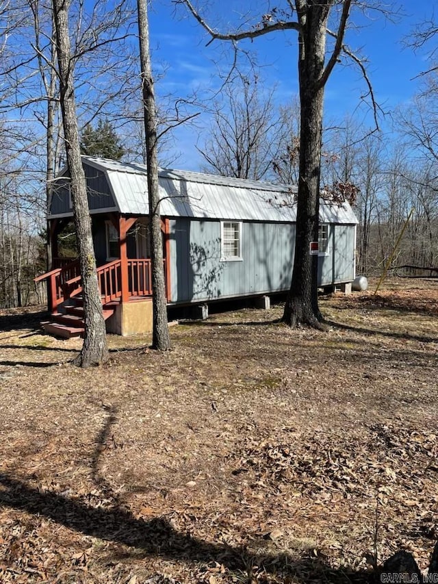 exterior space featuring a gambrel roof and metal roof