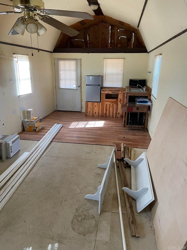 unfurnished living room featuring a ceiling fan and vaulted ceiling