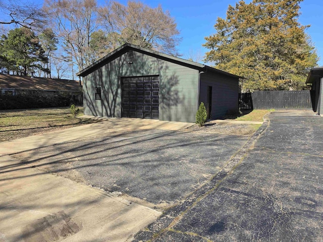 view of outdoor structure featuring an outdoor structure, driveway, and fence